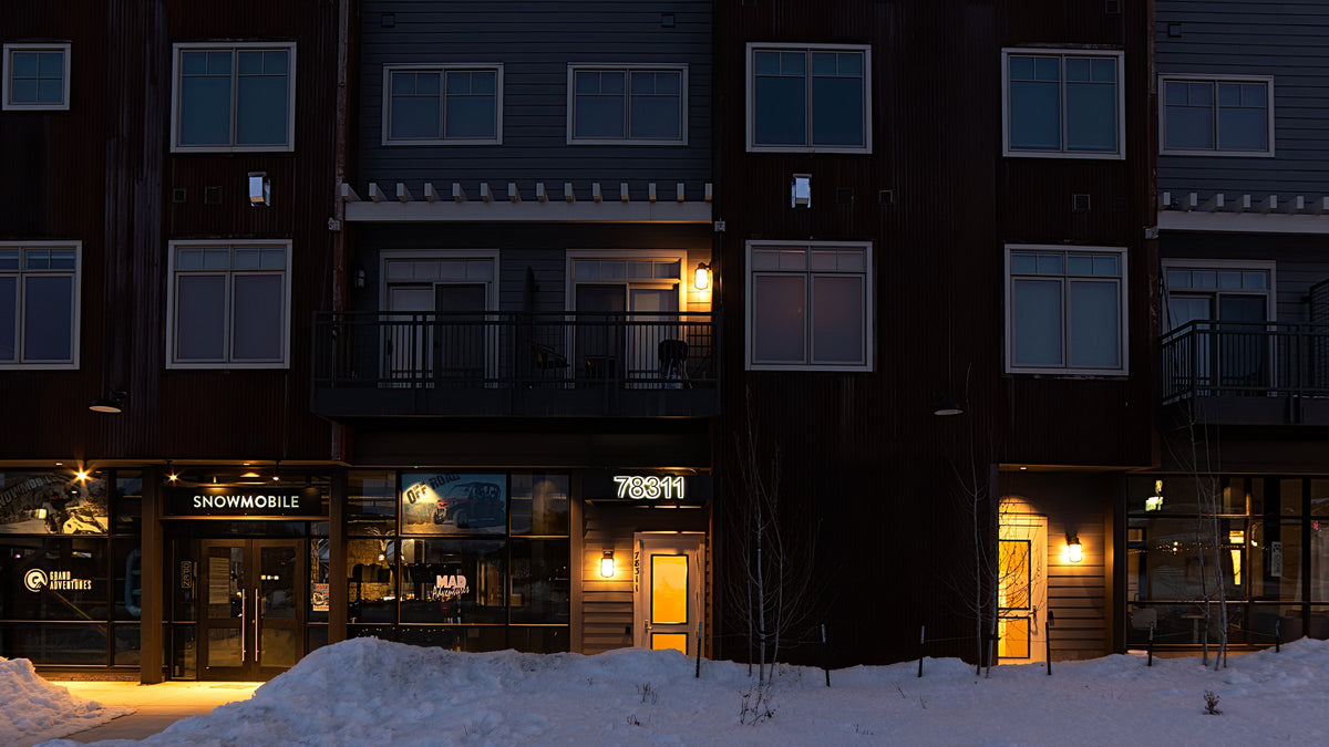 Lit building number above a storefront at dusk